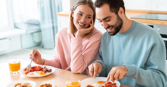 夫婦仲良く幸せそうに朝食を食べている写真